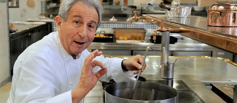 Michel Guerard tenant une louche dans une gamelle