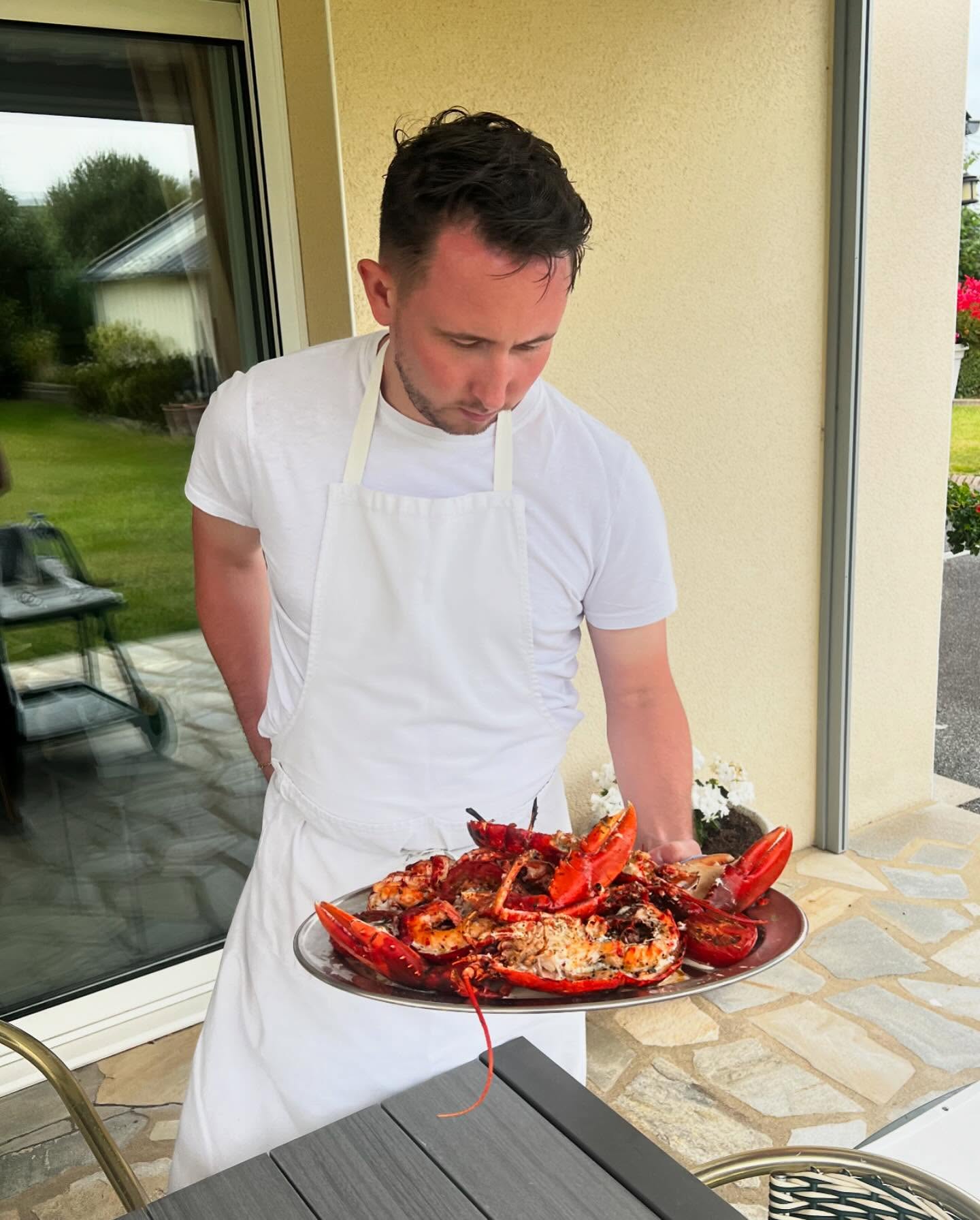 Vincent le Moal en train de préparer des homards sur la terrasse d'une maison